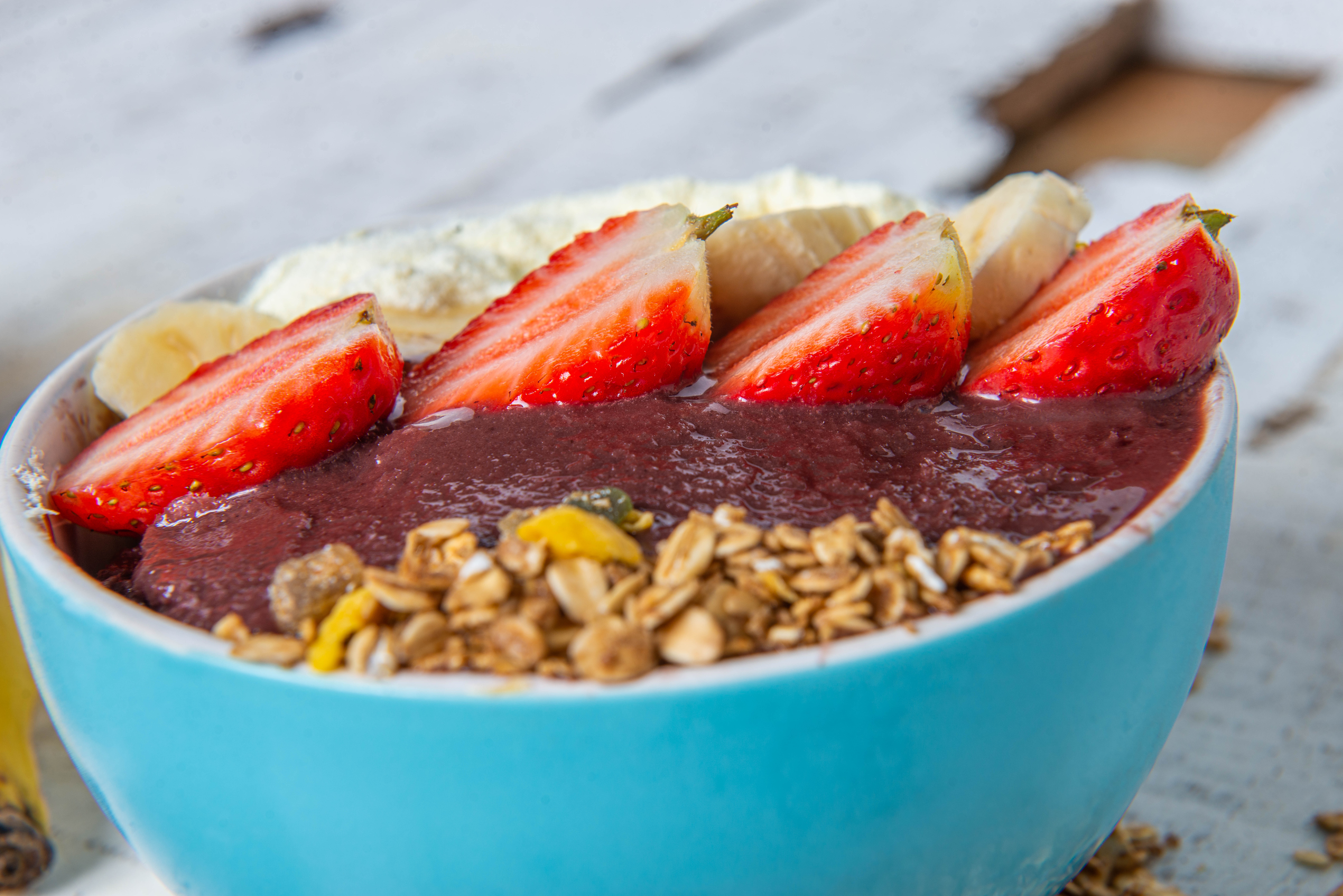 Tigela de açaí com granola e toppings variados — controle de gramatura em açaiteria